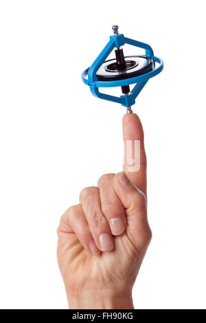 Finger mit einem drehenden Gyroskop auf weißem Hintergrund Stockfoto