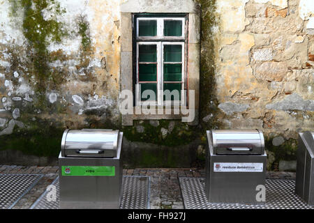 Neue Metall recycling-Behälter für Glas und häusliche Abfälle außerhalb altes Steinhaus, Caminha, Nordportugal Stockfoto