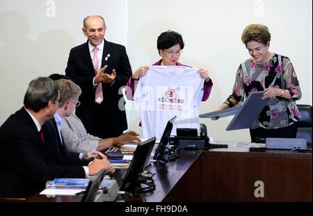 Brasilien Präsidentin Dilma Rousseff stellt Generaldirektor der World Health Organisation Margaret Chan mit Zika Null-t-Shirt, wie Gesundheitsminister Marcelo Castro während eines Treffens der brasilianischen Regierung Maßnahmen zur Bekämpfung Zika-Virus und die Mücke Aedes Aegypti 23. Februar 2016 in Brasi Lia, Brasilien diskutieren blickt auf. Stockfoto