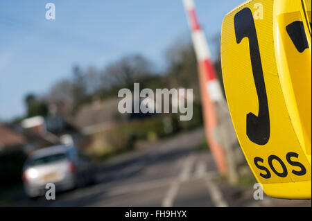 SOS-Notfall-Telefon auf unbemannte Bahnübergang mit Auto und Barrier ausgelöst Stockfoto