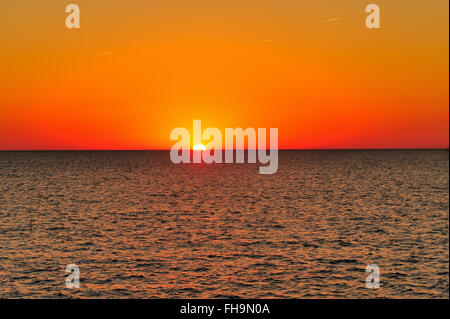 Chicago, Illinois, USA. Die Sonne den Horizont bei Sonnenaufgang über dem Lake Michigan wie aus dem Chicago Montrose Hafen gesehen. Stockfoto