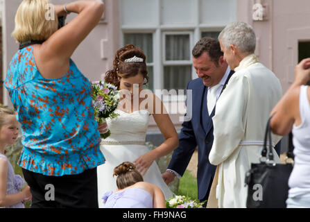 Vor ihrer Hochzeit hat eine Braut ihr angepasst durch eine Brautjungfer Kleid Stockfoto