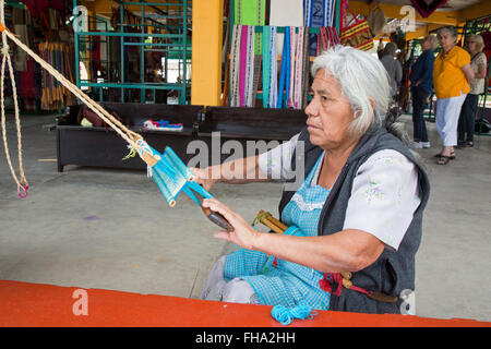 Santo Tomás Jalietza, Oaxaca, Mexiko - eine Frau arbeitet auf einem Rückengurt Webstuhl auf dem Weber-kooperative. Stockfoto