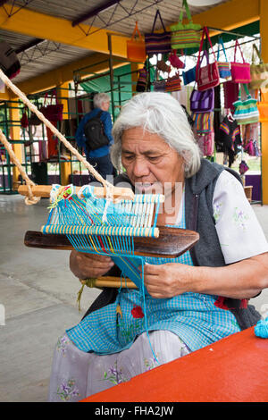 Santo Tomás Jalietza, Oaxaca, Mexiko - eine Frau arbeitet auf einem Rückengurt Webstuhl auf dem Weber-kooperative. Stockfoto