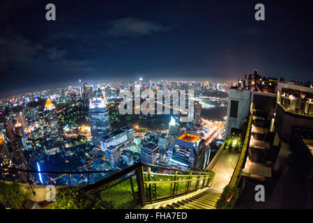 BANGKOK, Thailand – die glitzernde Skyline von Bangkok erstreckt sich unterhalb des Hotels vom Dachrestaurant Vertigo auf dem Dach des Banyan Tree Hotel aus. Wolkenkratzer und Hochhäuser beleuchten die weitläufige thailändische Hauptstadt mit unzähligen Lichtern und schaffen ein atemberaubendes Stadtpanorama. Stockfoto