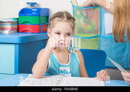 Eine fünfjähriges Mädchen engagiert sich in der Rechtschreibung am Tisch zu Hause Stockfoto