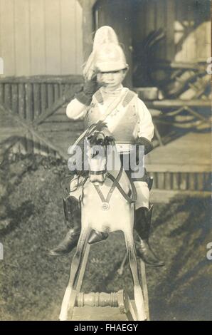 Porträt-Postkarte jungen gekleidet in Uniform auf Schaukelpferd Stockfoto