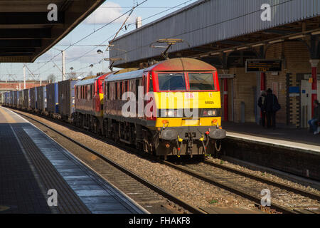 DB Cargo Container Freight Train am Warrington Bank Quay, gezogen von zwei e-Loks in DB rot Lackierung bei strahlendem Sonnenschein, Warrington, England. Stockfoto