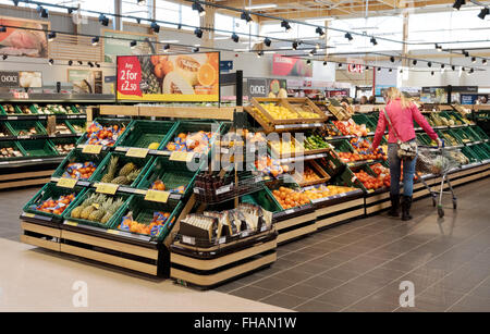 Supermarkt Gemüse GROSSBRITANNIEN; eine Frau kaufen Obst Obst und Gemüse Gang, Tesco Supermarkt store Innenraum, Suffolk UK Stockfoto