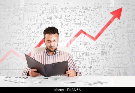 Geschäftsmann, sitzen am Tisch mit Markt-Diagramme Stockfoto