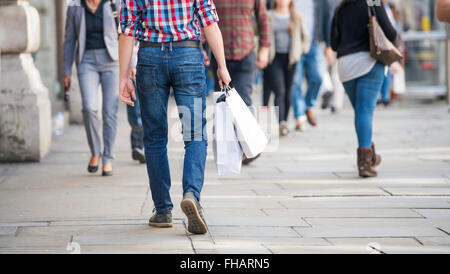 Nicht erkennbare Mann mit Einkaufstüten in der Straße, Ansicht von hinten Stockfoto