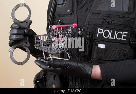 Polizist mit Handschellen und Einkaufswagen in Konzept der Ladendiebstahl Stockfoto