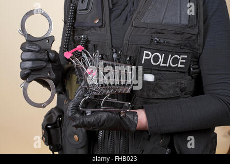 Polizist mit Handschellen und Einkaufswagen in Konzept der Ladendiebstahl Stockfoto