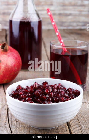 Granatapfel Samen mit Saft in ein Glas und eine Flasche Stockfoto