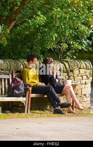 Junges Paar sitzt auf einer Bank, die Sonne zu genießen. Stockfoto