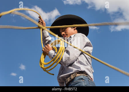 Eine mexikanische Charro oder Cowboy Praktiken Abseilen Fähigkeiten auf seinem Pferd vor einem Charreada Wettkampf auf einer Hacienda-Ranch in Alcocer, Mexiko. Die Charreada ist eine traditionelle mexikanische Rodeo und testet die Fähigkeiten des Cowboys reiten, Abseilen und Vieh zu kontrollieren. Stockfoto