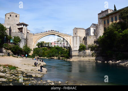 Menschen versammeln sich lokale Taucher zu beobachten und abenteuerliche Touristen springen aus dem 16. Jahrhundert wiederaufgebaut osmanische Brücke Stari Most oder die Alte Brücke in Mostar. Stockfoto