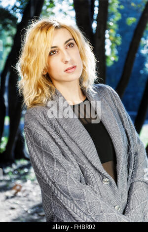 Mode Mädchen fotografiert in der Natur. Rückseite mit Bäume und Schatten Hintergrund beleuchtet. Stockfoto