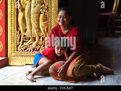 Thailändische Mutter und Kind in der buddhistischen WAT XIENG THONG (Tempel der goldenen Stadt), erbaut im Jahre 1560 - LUANG RACHENTUPFER, LAOS Stockfoto
