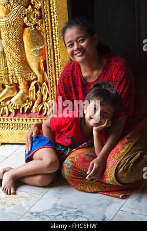 Thailändische Mutter und Kind in der buddhistischen WAT XIENG THONG (Tempel der goldenen Stadt), erbaut im Jahre 1560 - LUANG RACHENTUPFER, LAOS Stockfoto