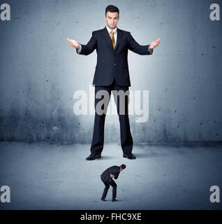 Wütend Riesengeschäft Mann Lokking an kleinen Kerl Stockfoto