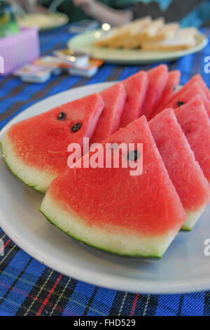 Wassermelone In die weiße Platte auf dem Esstisch. Stockfoto