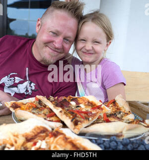 Glücklich, Vater und Tochter Alter 40 und 8 kann es kaum erwarten, in einen köstlichen Pizza auf sein Deck zu tauchen. Zawady Zentralpolen Stockfoto