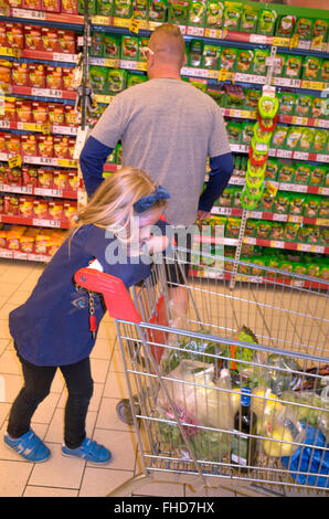 Tochter wartet geduldig, während Papa Geschäfte im Supermarkt. Tomaszow Mazowiecki Zentralpolen Stockfoto