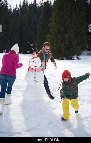 glückliche Familie Gebäude Schneemann Stockfoto