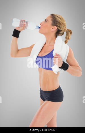 Zusammengesetztes Bild starke blonde aus Flasche Wasser trinken Stockfoto