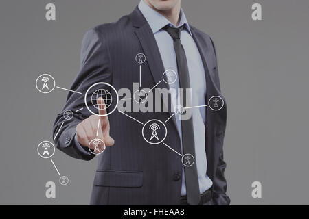 Business-Mann auf Knopfdruck Touchscreen. Welt Karte Türme Stockfoto