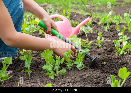 kleines Mädchen im Garten mit Pflanzen Stockfoto