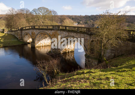 Fluß Derwent fließt unter der Parkland-Brücke auf dem Chatsworth Anwesen in Derbyshire Stockfoto