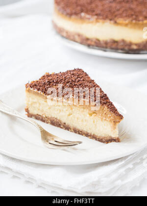 Stück vegane Hirse Käsekuchen mit Datum Karamell auf Klampe Hintergrund. Stockfoto