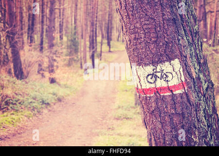 Vintage getönten Bike Trail Schild gemalt auf einem Baum im Wald. Stockfoto