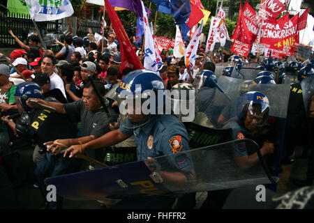 Philippinen. 25. Februar 2016. AktivistInnen durchbrechen die Polizei Blockade im EDSA, Quezon CIty. Militante Aktivisten kollidierte mit der Polizei, wie sie versuchen, in Richtung EDSA Schrein in Quezon-Stadt zu marschieren. Die Demonstranten fordern, dass "echte '' Demokratie zum 30. Jahrestag der EDSA People Power Revolution mit Präsident Ferdinand Marcos gestürzt. © J Gerard Seguia/ZUMA Draht/Alamy Live-Nachrichten Stockfoto