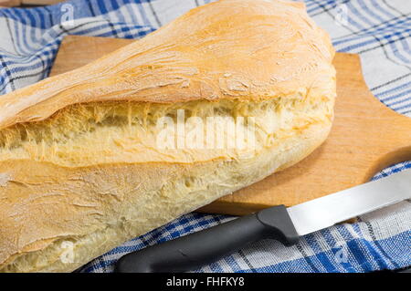 Hausgemachtes Brot und ein Messer auf dem Tisch Stockfoto