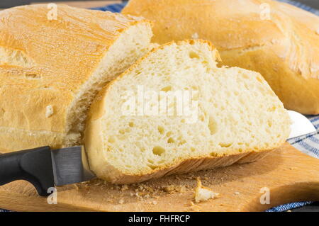 Hausgemachtes Brot und ein Messer auf dem Tisch Stockfoto