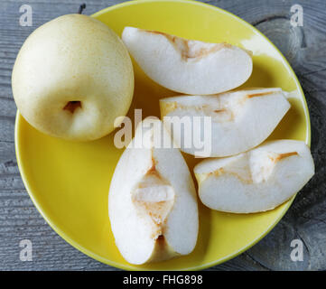 geschnittene gelbe Birne in einer Schüssel auf einem rustikalen Tisch Stockfoto