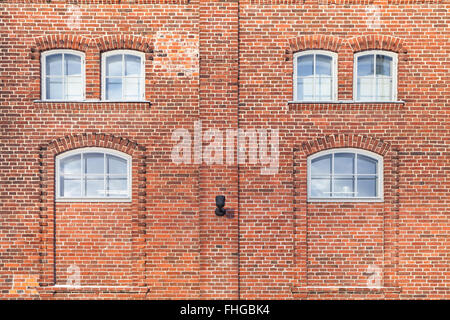 Roten Backsteinmauer mit kleinen Fenstern, Haus Fassade Hintergrundtextur Leben Stockfoto