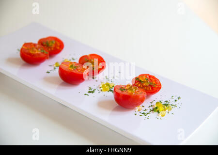 Cherry-Tomaten mit Perlen von Olivenöl und Petersilie. Stockfoto