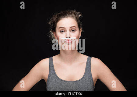 junge Frau mit Zigarette Schnurrbart, Rauchen Konzept auf schwarzem Hintergrund Stockfoto