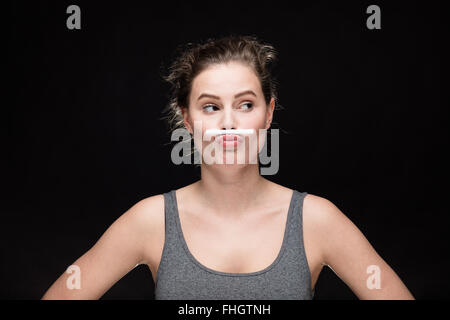 junge Frau mit Zigarette Schnurrbart, Rauchen Konzept auf schwarzem Hintergrund Stockfoto