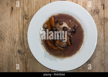 Coq Au Vin von oben. Klassische französische Gericht zubereitet Huhn in Rotwein mit Gemüse serviert Stockfoto