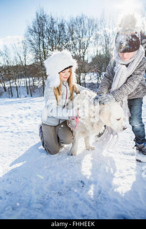 Bruder und Schwester spielen mit Hund Stockfoto