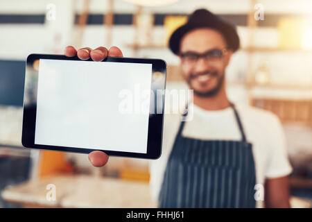 Porträt eines Mannes hält eine digital-Tablette mit ein leeres Display hautnah. Mann arbeitet im Café mit einem Touch-Screen-computer Stockfoto