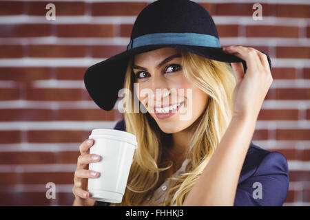 Schöne Frau mit Tasse Kaffee zum mitnehmen Stockfoto