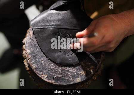 Bücherregal mit Schuhen. Elegante Herren Schuhe nach Maß angefertigt. Klassische Herren Eleganz, genähte Schuhe bei der Schuster. Stockfoto