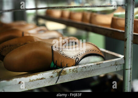 Bücherregal in der Studio-Schuster an die eingestellte Paare von eleganten Herrenschuhe. Elegant, aber männlich, manuelle Präzision Arbeit Schuster Stockfoto