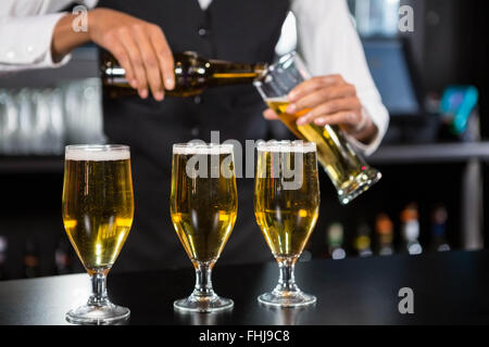 Drei Gläser Bier servierfertig auf Bartheke Stockfoto